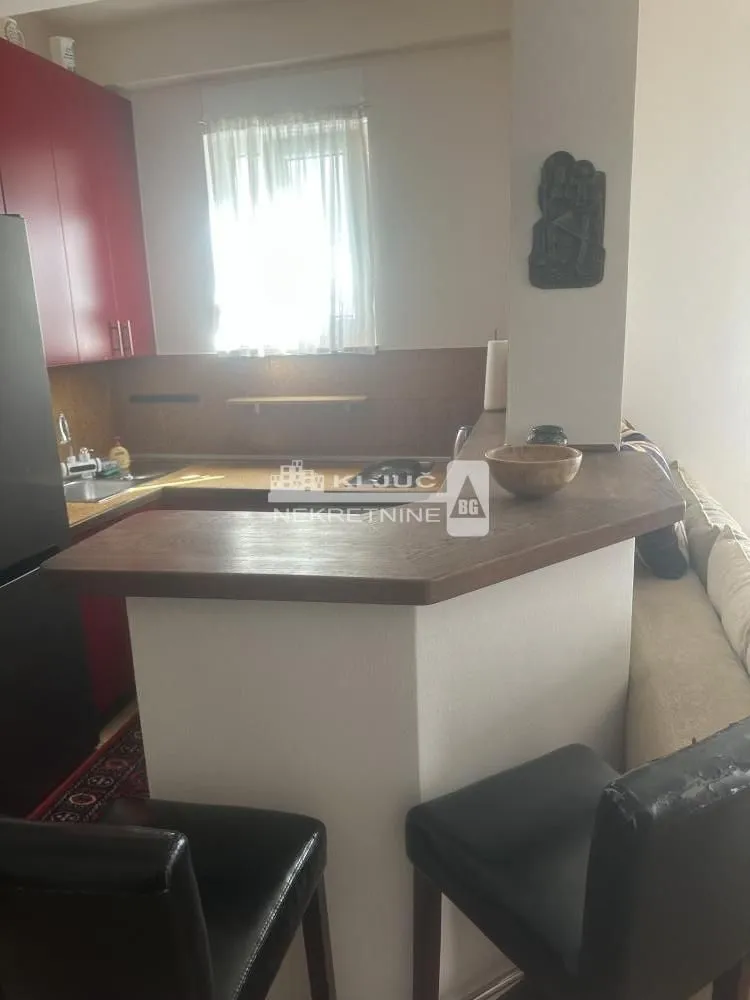 Kuhinja sa šankom i trpezarijskim stolom.
