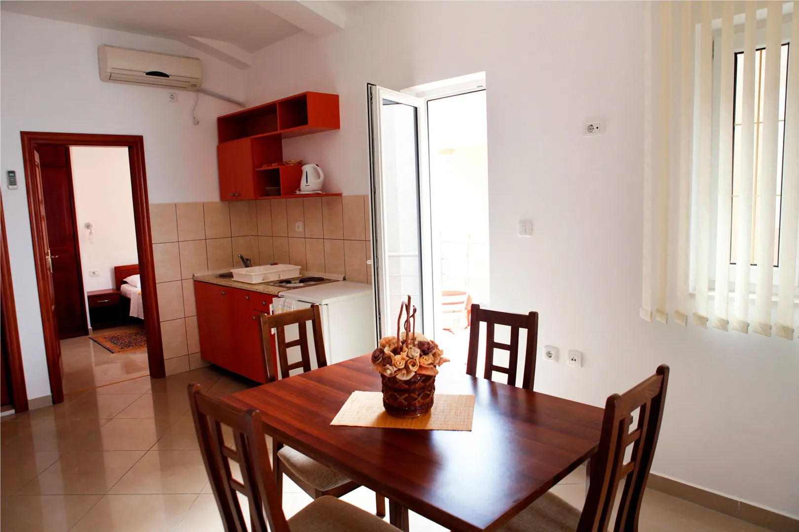 Dining area with a wooden table and chairs, overlooking the kitchen.