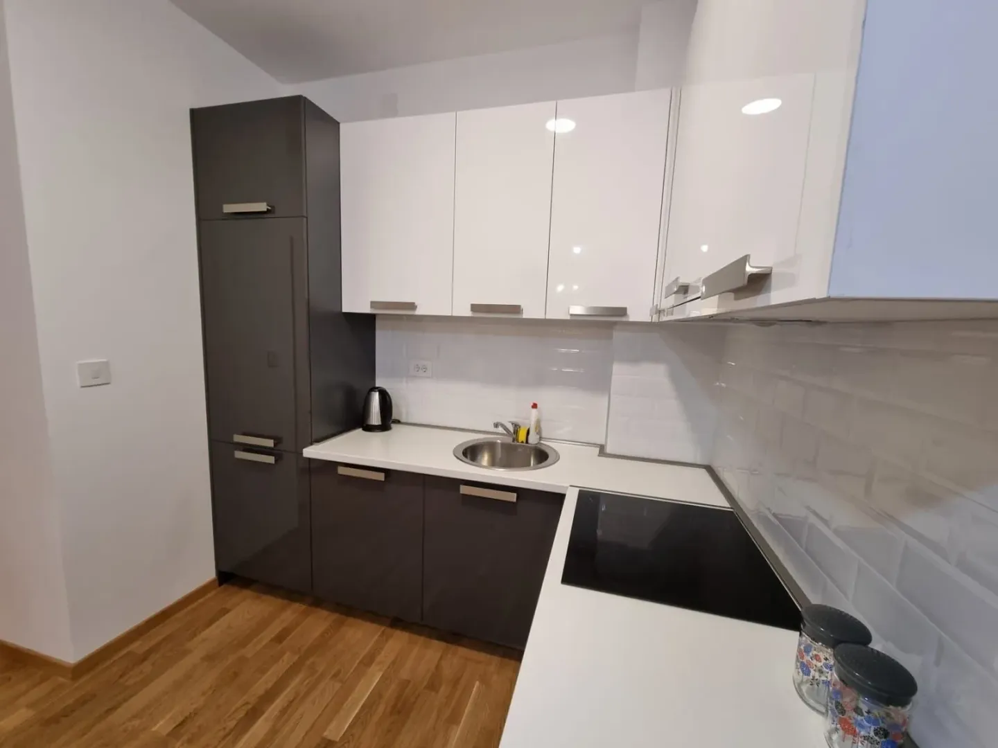 Modern kitchen with dark and white cabinets and a white countertop.