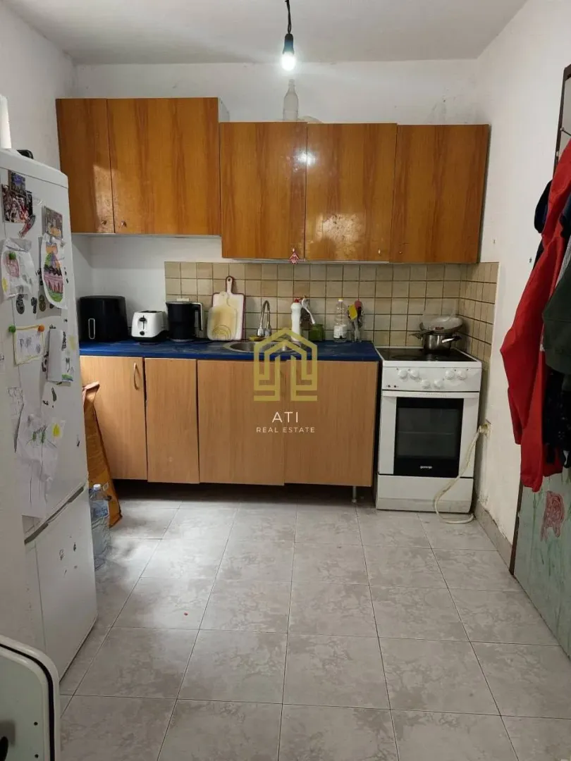 Manja kuhinja sa drvenim elementima i šporetom.