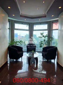Smaller living room with armchairs and a glass coffee table in front of large windows. - image 6