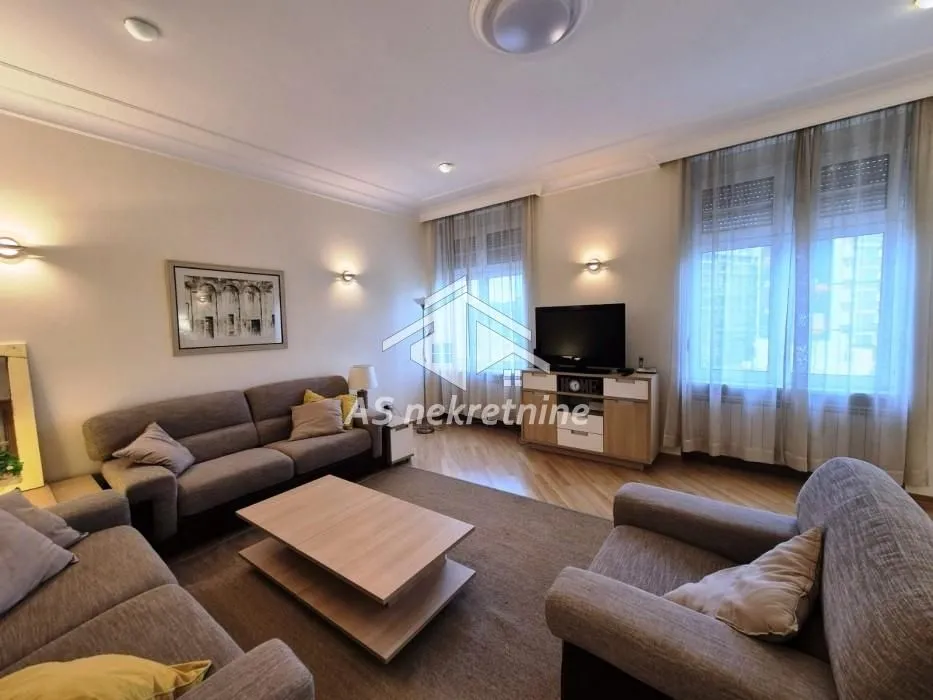 Spacious living room with seating set and television.