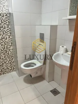 Small bathroom with white tiles, toilet bowl, and sink. - image 4
