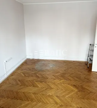 Empty room with wooden parquet flooring and light walls. - image 4