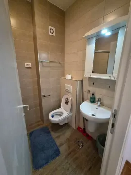Small bathroom with ceramic tiles, washbasin and toilet. - image 9