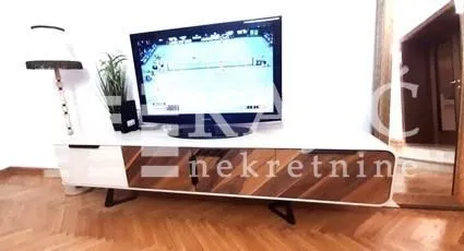 Dnevna soba sa TV komodom i televizorom.