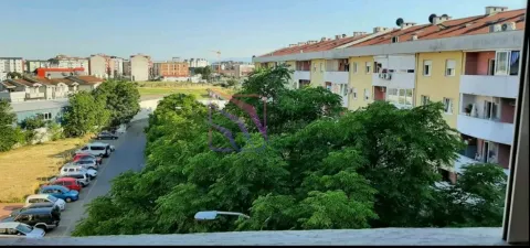 View from the window overlooking surrounding buildings, green areas, and parking. - image 5