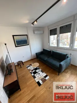 Dnevna soba sa garniturom, TV komodom i prozorom. - image 4