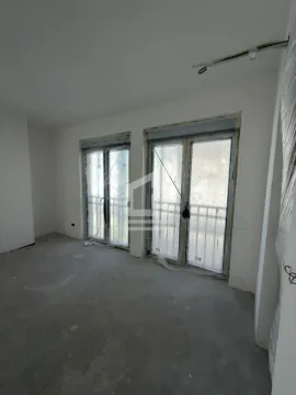 Prazna prostorija u sivoj fazi izgradnje sa dva balkonska vrata prekrivena zaštitnom folijom. - image 2