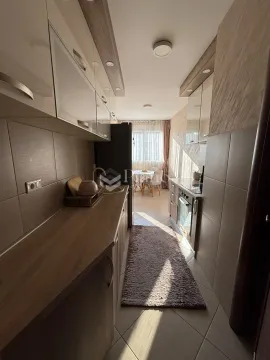 Long kitchen with wooden countertops and a dining area in the background. - image 3