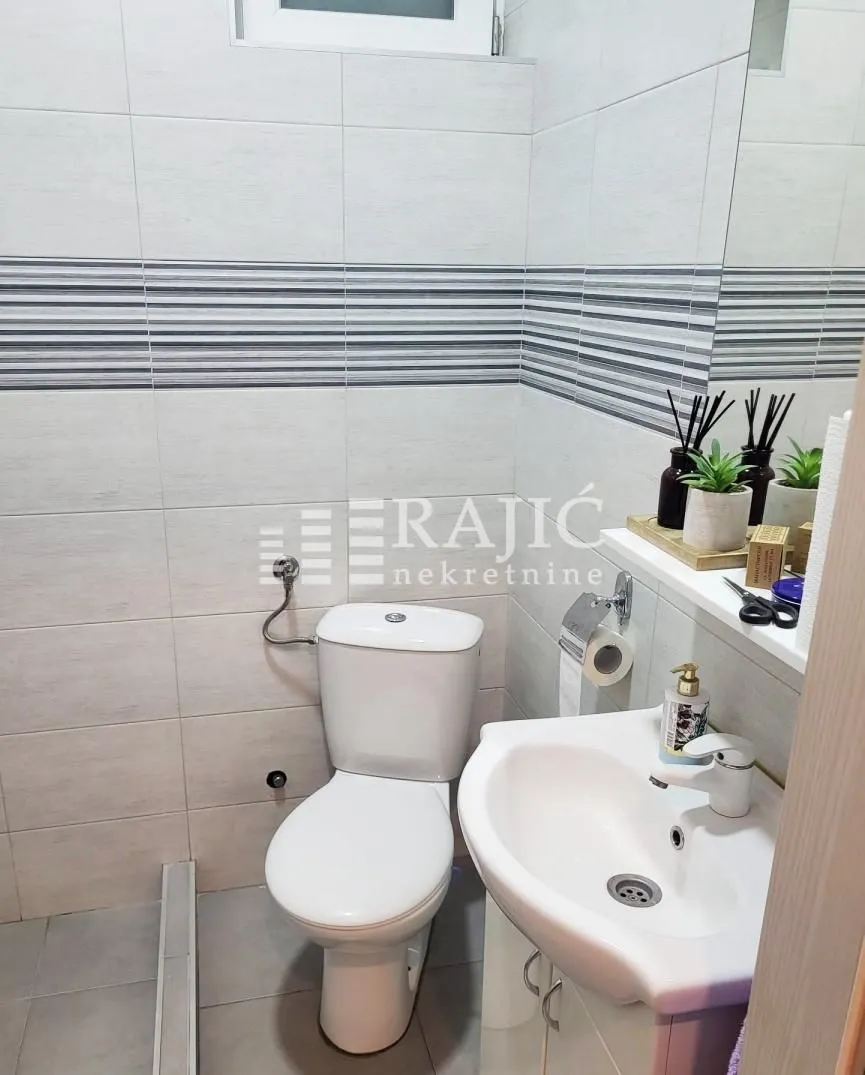 Small bathroom with a shower cabin, washbasin, and toilet.