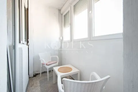Enclosed balcony with a white table and two chairs. - image 6