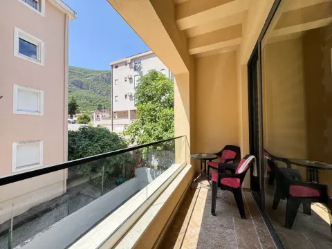 Natkrivena terasa sa garniturom za sedenje i pogledom na okolne zgrade i brdo. - image 13