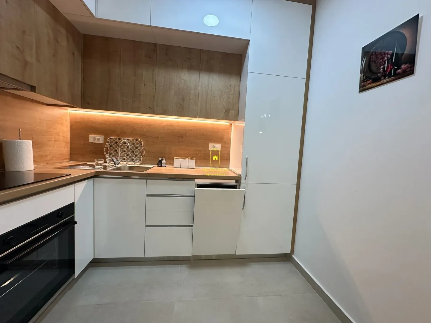 Modern kitchen with white and wooden elements.