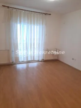 Prazna soba sa laminatom i balkonskim vratima sa belim zavesama. - image 6
