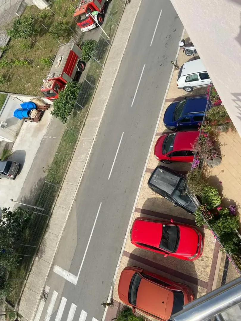 View from the terrace overlooking the street and parking area in front of the building.
