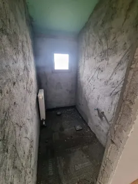 Prostorija u sivoj fazi gradnje sa malim prozorom. - image 12