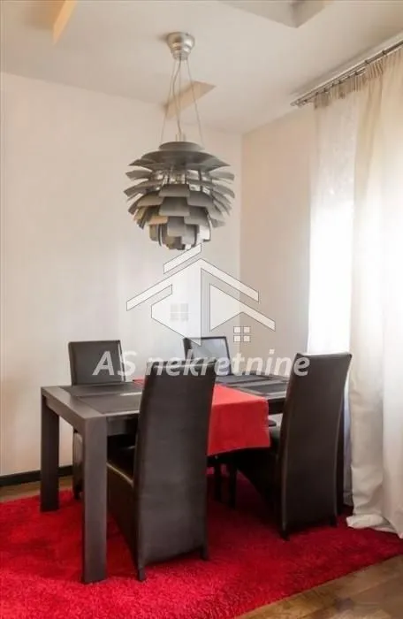 Dining area with a table, chairs, and a chandelier.