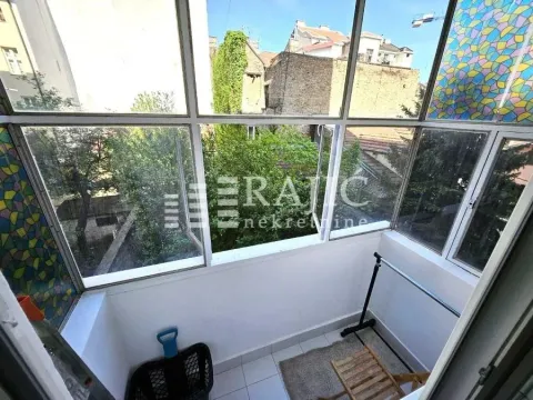 Glazed balcony with a view of surrounding buildings and greenery. - image 20