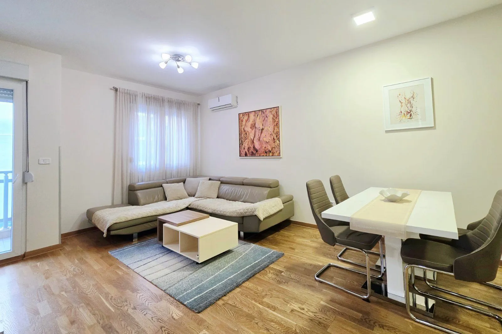 Living room with a sectional sofa, coffee table, and a dining table with chairs.