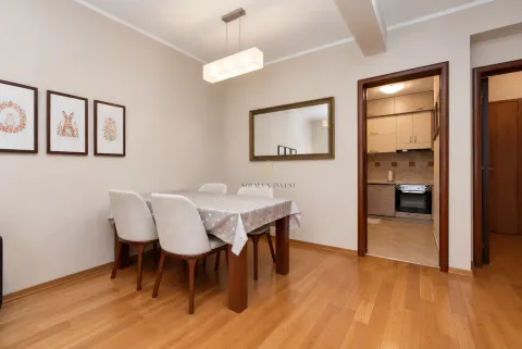 Dining area with a wooden table and chairs, with a view into the kitchen. - image 11