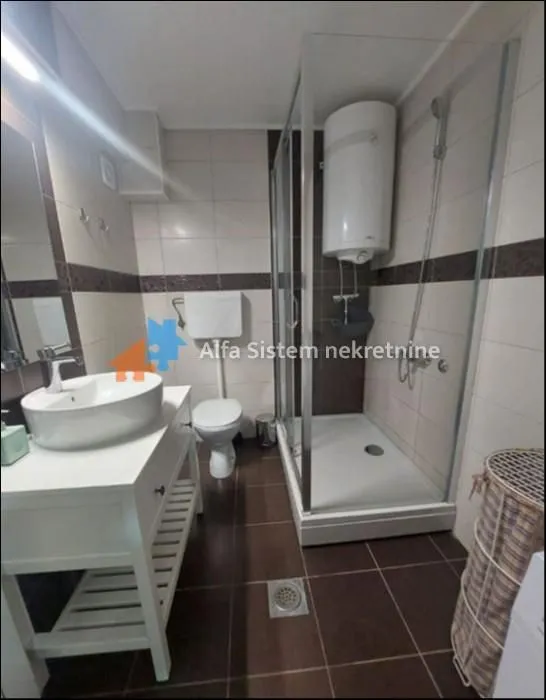 Bathroom with a shower cabin, washbasin, and toilet.