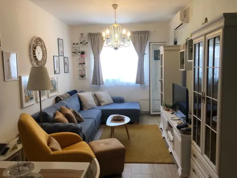 Living room with a sectional sofa, armchair, and TV unit. - image 15