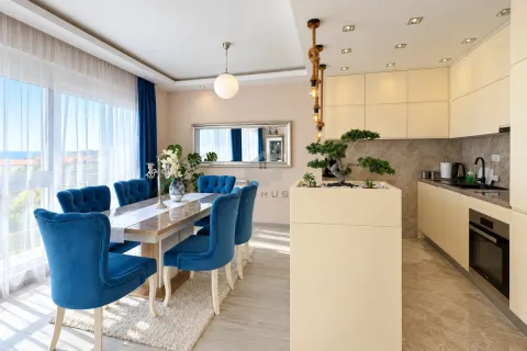 Living room with dining area and kitchen in light tones and blue chairs. - image 21