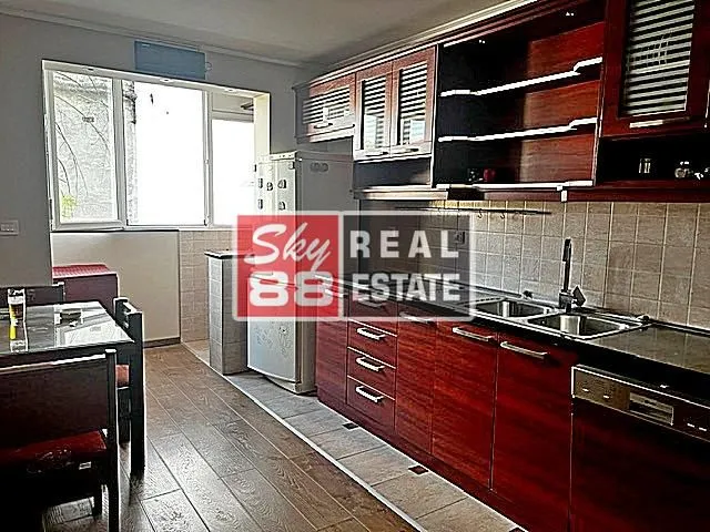 Kitchen with dark wooden units and a dining table.