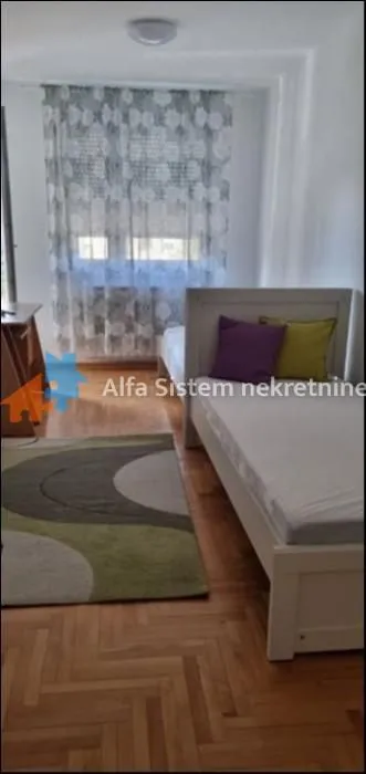 Nameštena spavaća soba sa krevetom i prozorom.