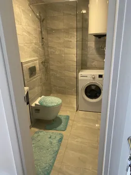 Moderno opremljeno kupatilo sa tuš kabinom i veš mašinom. - image 5