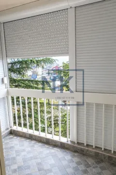 Zastakljeni balkonski prostor sa roletnama i pogledom na okolinu. - image 10