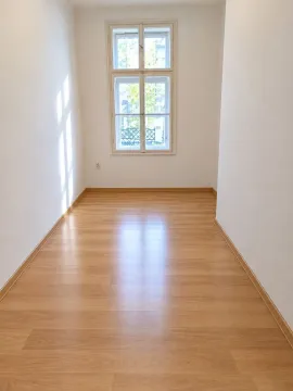 Prazna soba sa drvenim podom i jednim prozorom. - image 4