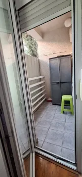 Small tiled balcony with a cabinet and a clothes drying rack. - image 4
