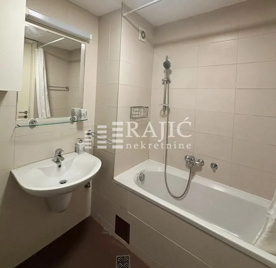 Kupatilo sa kadom, umivaonikom i ogledalom.