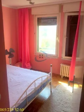 Spavaća soba sa krevetom, prozorom i roze zavesama. - image 13