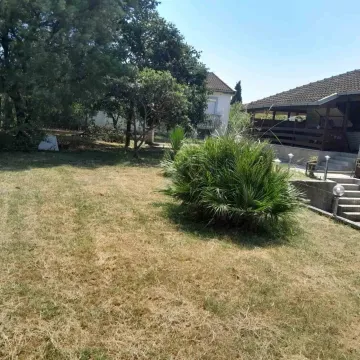 Prostrano dvorište sa travnjakom i drvećem pored kuće. - image 5