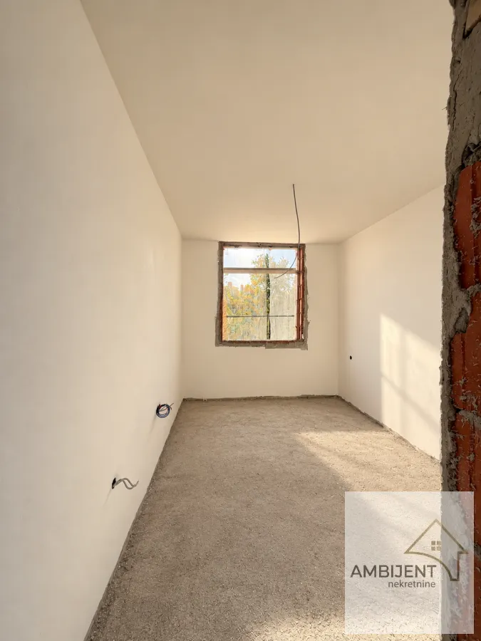 Unfurnished room under construction with plastered walls and a window.