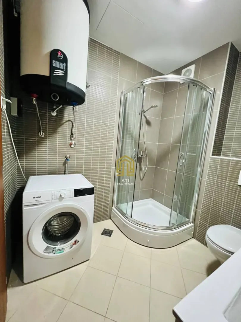 Bathroom equipped with a shower cabin, water heater, and washing machine.