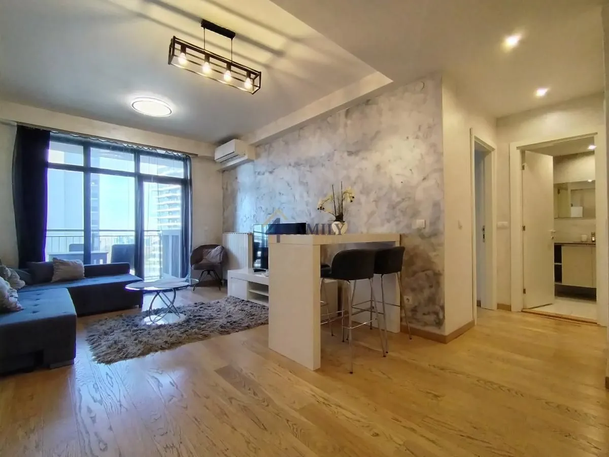 Spacious and bright living room with a sofa and dining bar.