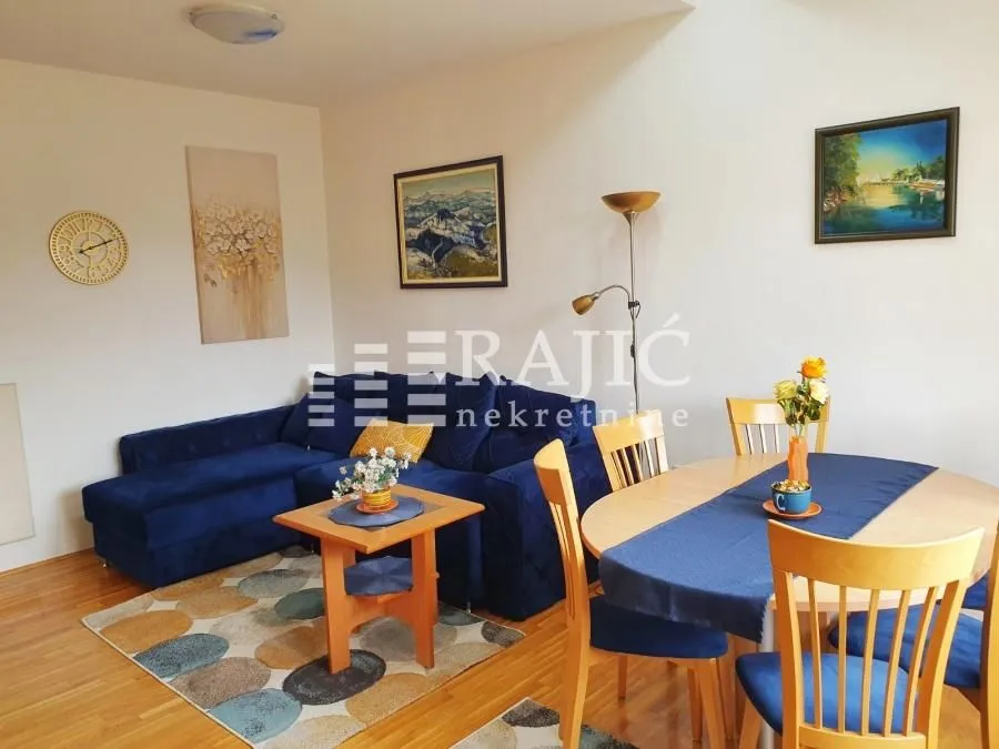 Living room with a dining area and a blue corner sofa.