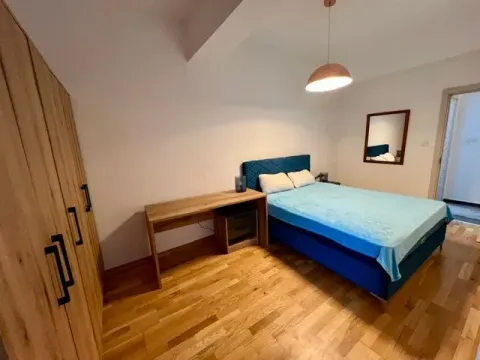 Furnished bedroom with a double bed, desk, and large wardrobe. - image 7
