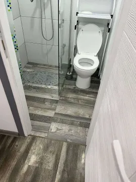 Small bathroom with a shower cabin and toilet. - image 10