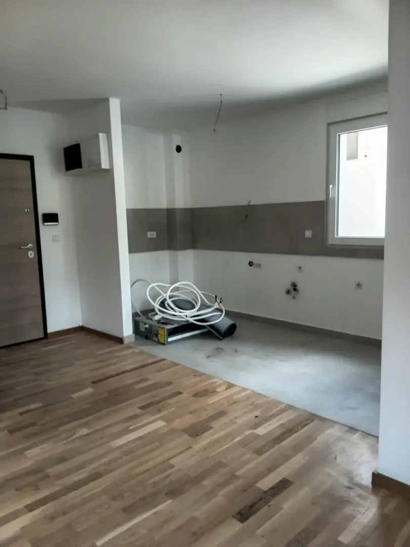 Nezavršena kuhinja u prostoru sa drvenim podom.