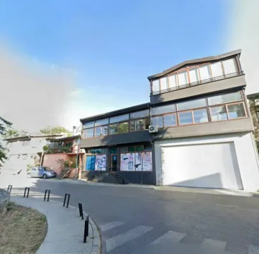 View of the exterior of a commercial and residential building from the street. - image 2