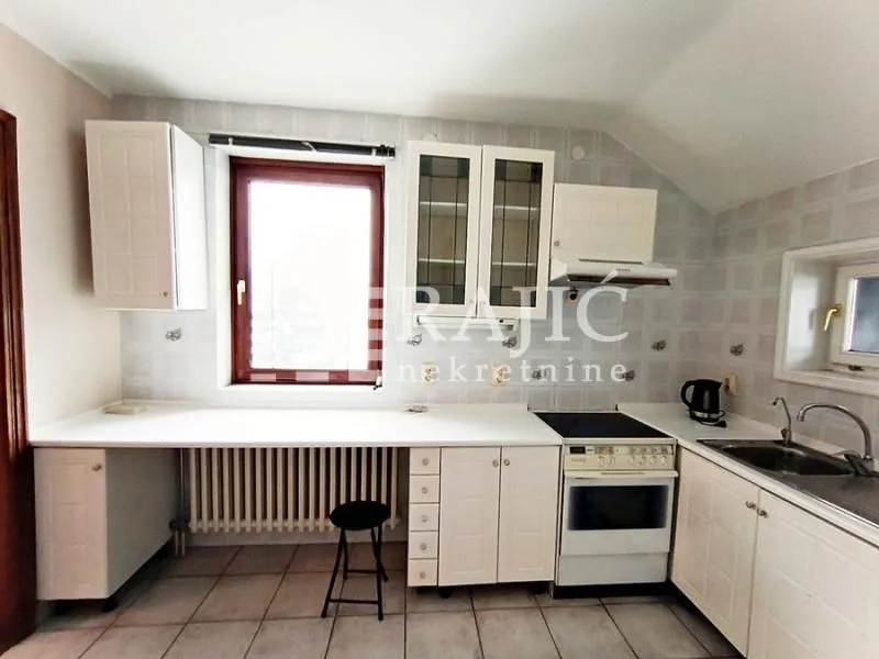 Smaller kitchen with white cabinets and a stove.