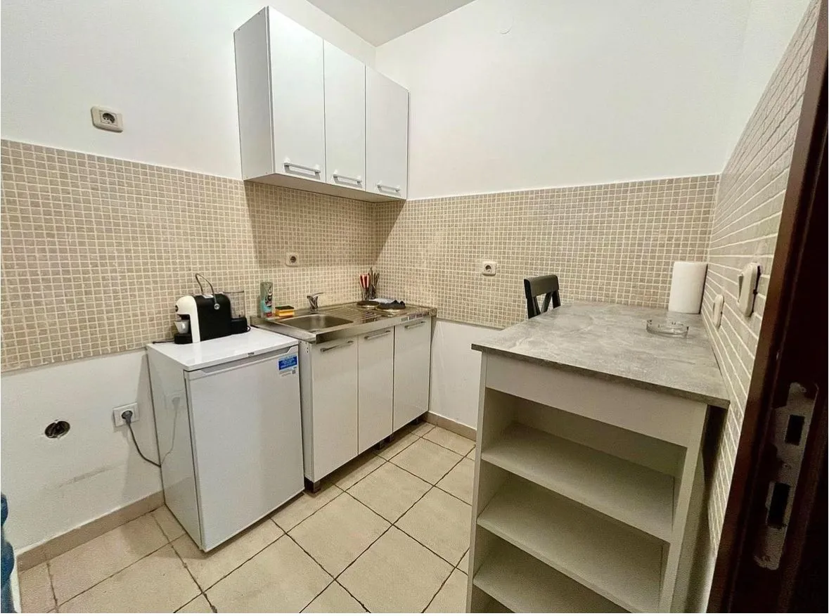 Small, functional kitchen with white cabinets.