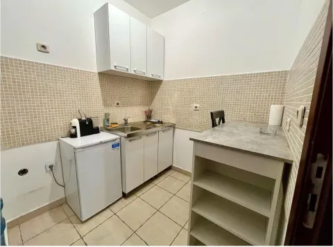 Small, functional kitchen with white cabinets. - image 3
