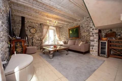 Living room with stone walls, wooden ceiling beams and a seating set. - image 14