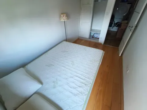 Smaller bedroom with a bed and wooden floor. - image 16